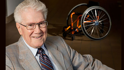 the late Tim Nugent shown in front of a wheelchair designed for sports