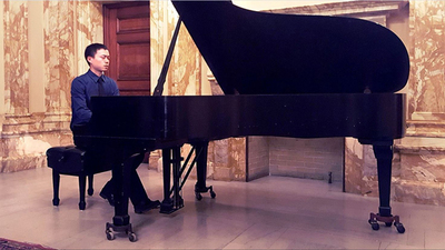 Barry Chang sits at a grand piano