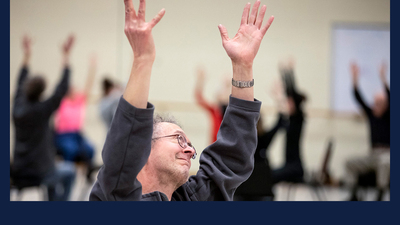 Gary Stitt, 61, stretches his arms to the sky as people gather for a Dance for People with Parkinson’s class at Krannert Center for the Performing Arts. All photos by Fred Zwicky