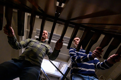 Photo of two chimes players moving the levers to play the Altgeld Chimes, seen from below.