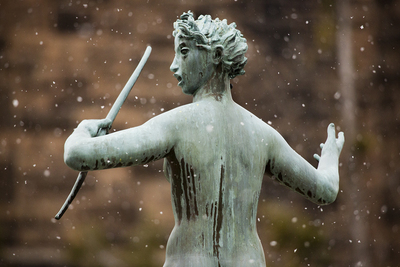 Snow falls around a female figure seen from behind