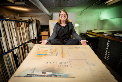 Architecture professor Marci Uihlein with a student drawing in the architecture department's student design archives.