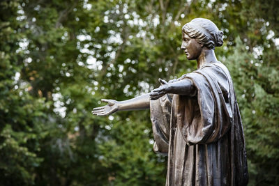 Photo of the bronze statue of Alma mater with her arms outstretched in a welcoming gesture.