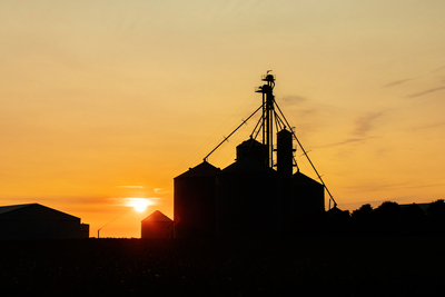 Silhouette of farm silos at sunset
