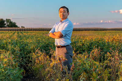 Kaiyu Guan standing in an agriculutural field in Illinois