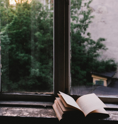 An open book on a window ledge.