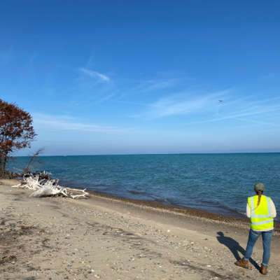 ISGS research technician Katie Braun flies a drone over Lake Michigan, collecting data by mapping magnetic materials both above and buried beneath the surface. 