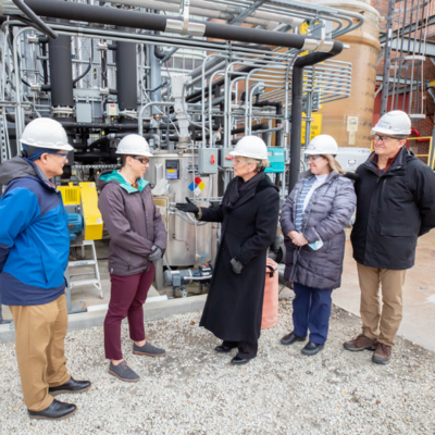 Kevin OBrien, Stephanie Brownstein, U.S. Secretary of Energy Jennifer M. Granholm, Susan Martinis, and Jeff Stein stand outside Abbott Power Plant