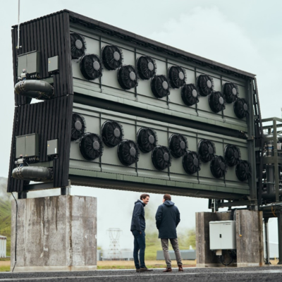 two men stand beneath a direct air capture installation in Iceland