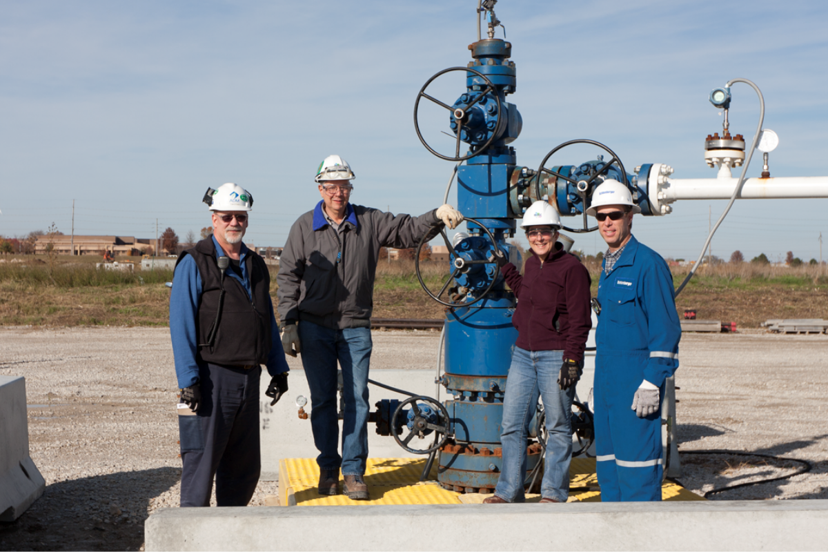 four people stand at the Illinois Basin Decatur Project injection well