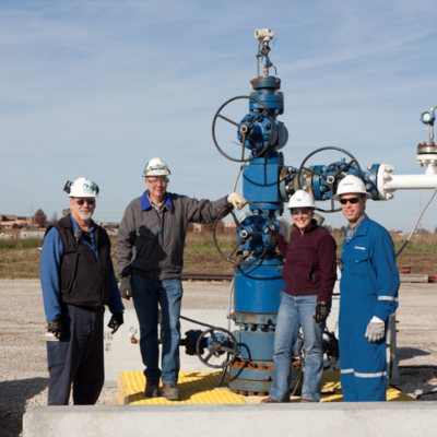 four people stand at the Illinois Basin Decatur Project injection well