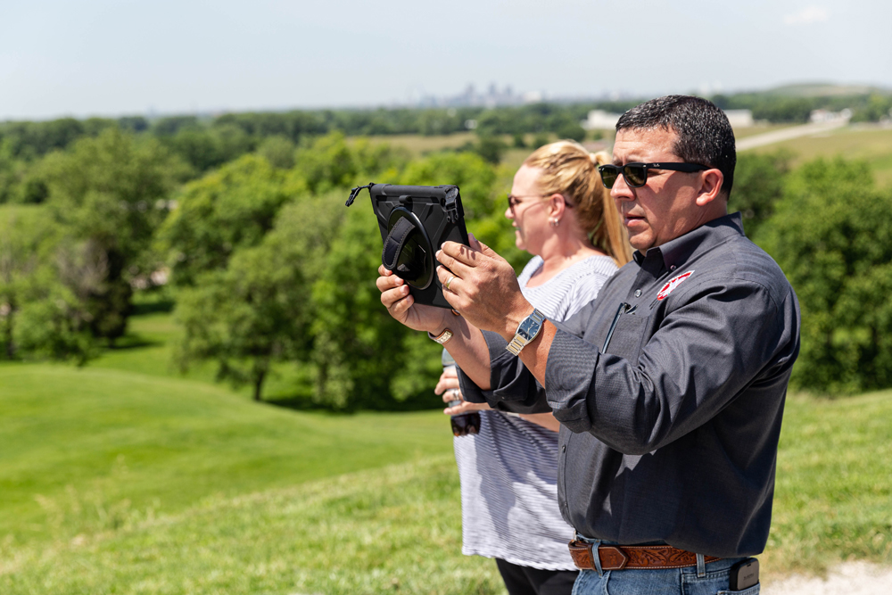 Chief Craig Harper views a reconstructed downtown Cahokia on the new augmented reality app from the top of Monks Mound while Second Chief Rosana Dobbs takes in the view of Cahokia’s cityscape.