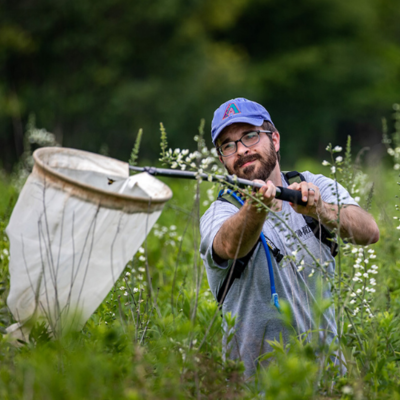 Tommy McElrath wields a net in Trelease prairie