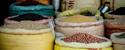 A variety of dried legumes in large cloth-lined cannisters