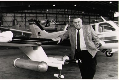 Stan Changnon leans on a small plane in a hangar