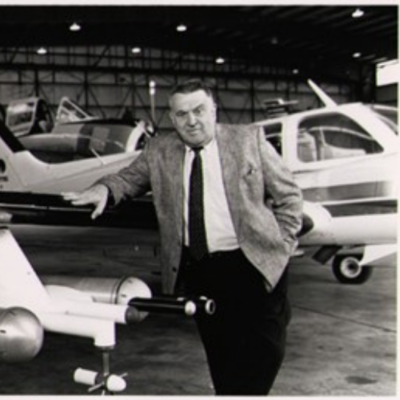 Stan Changnon leans on a small plane in a hangar
