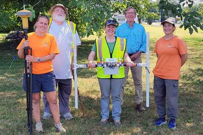 Two men, three women holding surveying equipment.