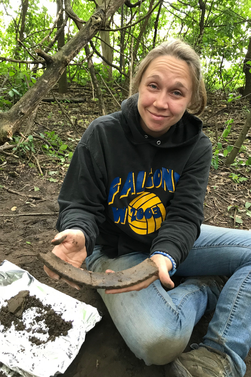 ISAS archaeologist Lauren Fitts holds a piece of the rim from a large ceramic vessel. This artifact was found at a site in the Elizabeth A. Conkey Forest Preserve in Cook County.