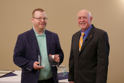 Daniel Abrams and Mark Ryan standing with the award.