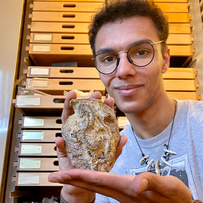 Caleb Bohus holding a microsaur fossil