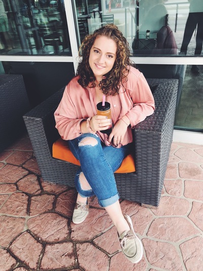 Grace smiles with a glass of ice coffee