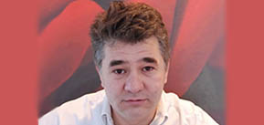 Headshot of Professor Gabriel Popescu in front of a red background