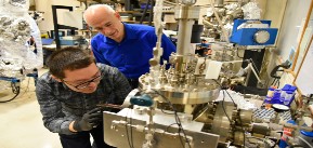 Postdoctoral researcher Gang Wang loads a sample into the system used to perform the nanotube crosslinking operation while Joseph Lyding looks on.