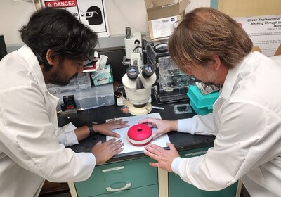 two scientists observe their prototype device