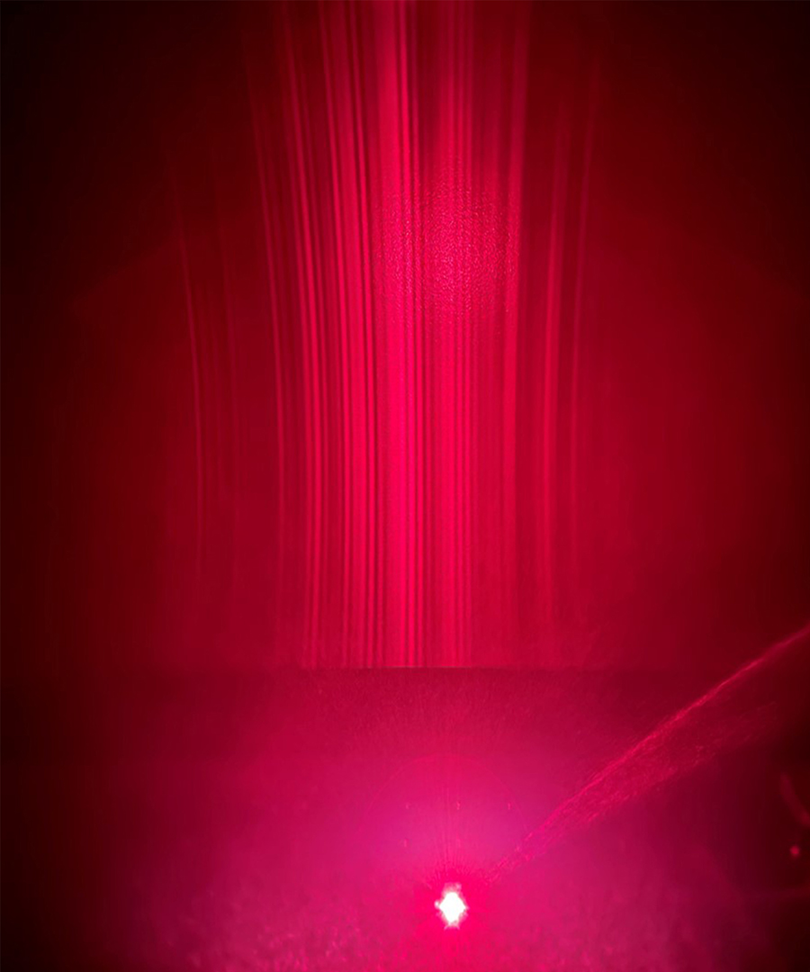 Vertical gradients of pink semiconductor laser light.